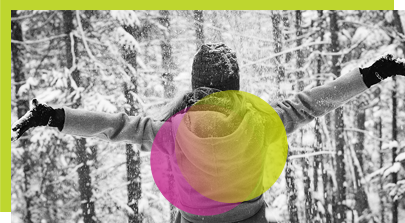 Frau im Kapuzenpullover breitet ihren Arm in der Nähe von Bäumen mit Schnee aus