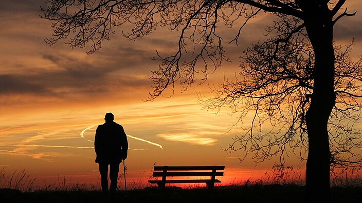 Mann mit Stock im Sonnenuntergang