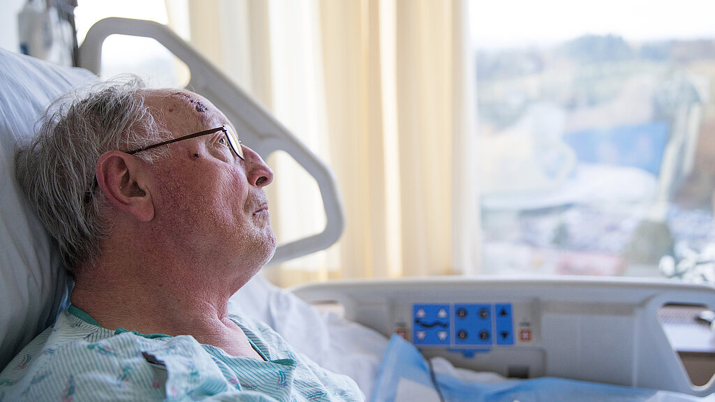 Älterer dementieller Mann im Krankenhausbett