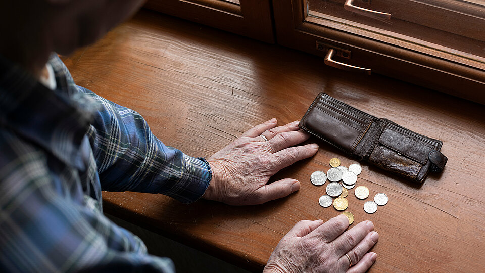 Ein alter Mann zählt sein Kleingeld